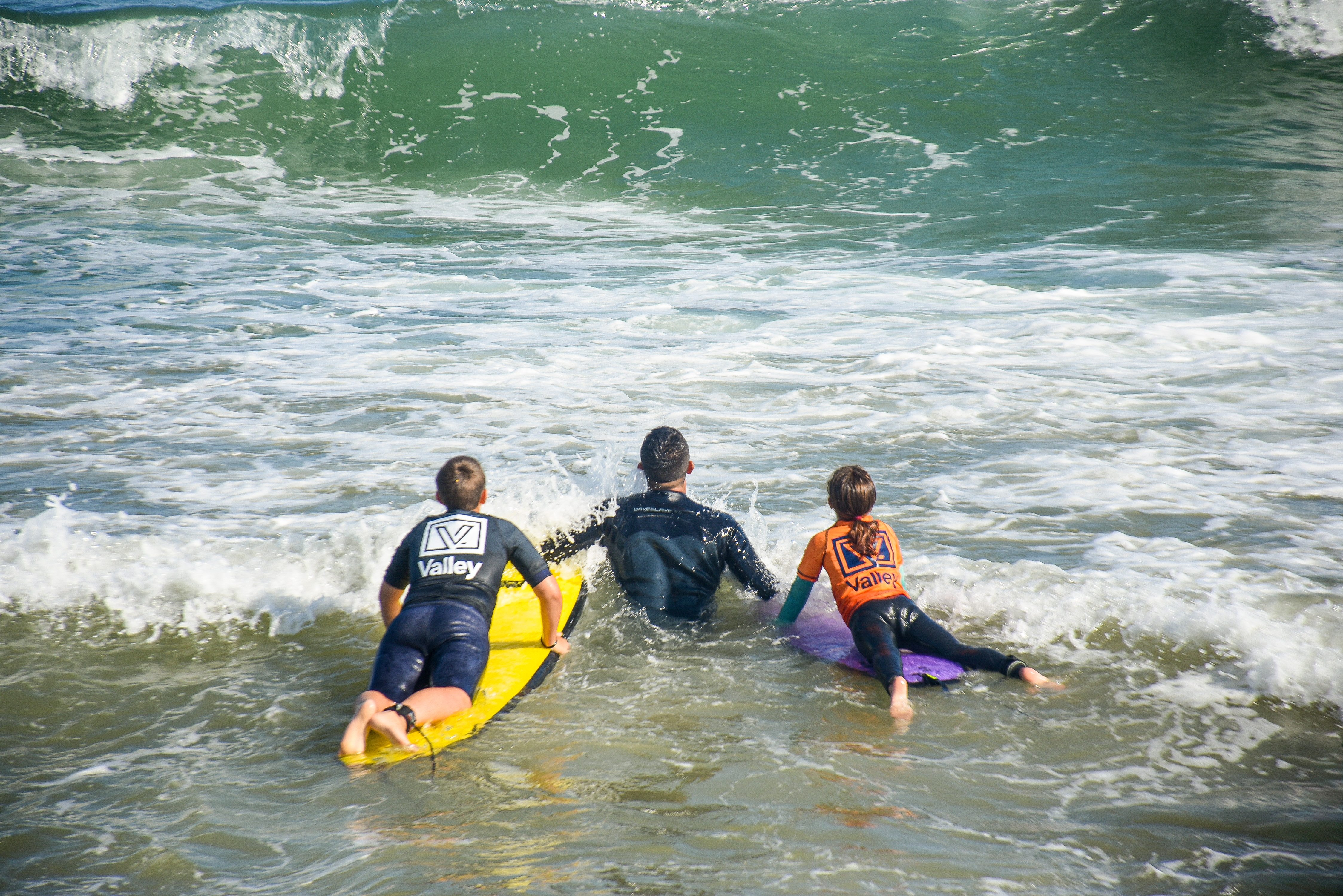 Grupo de surfistas entrando al mar en Miramar